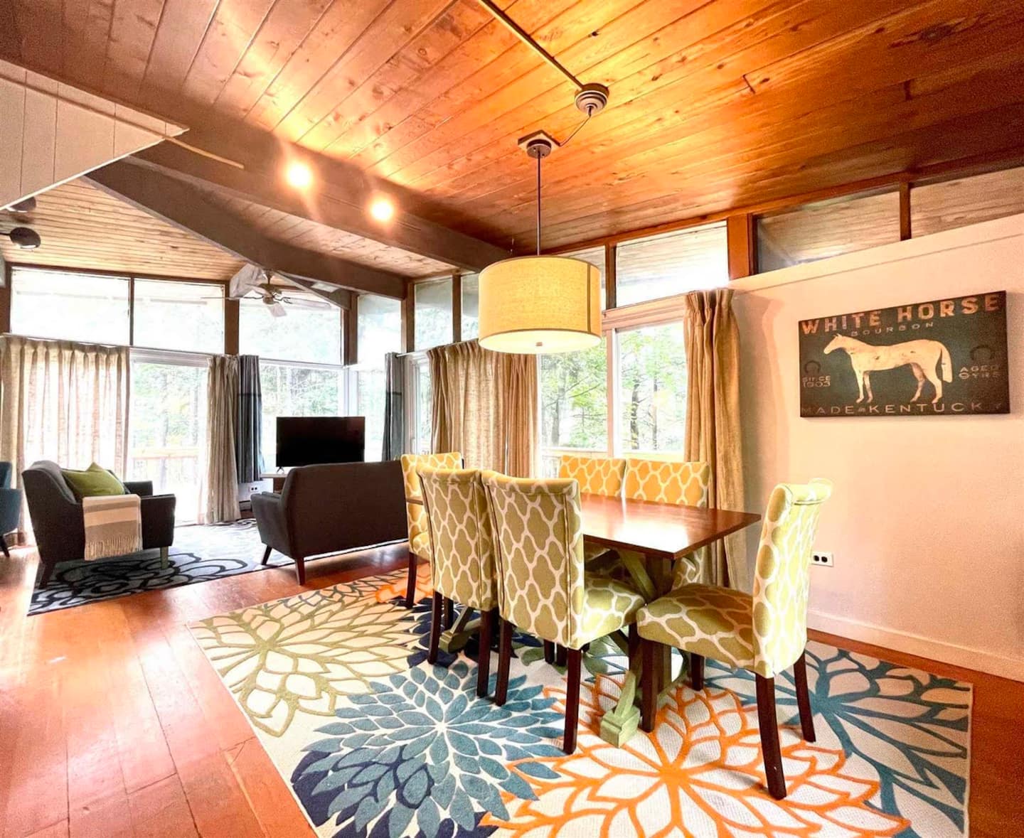 Open living and dining area with a wood dining table and forest views
